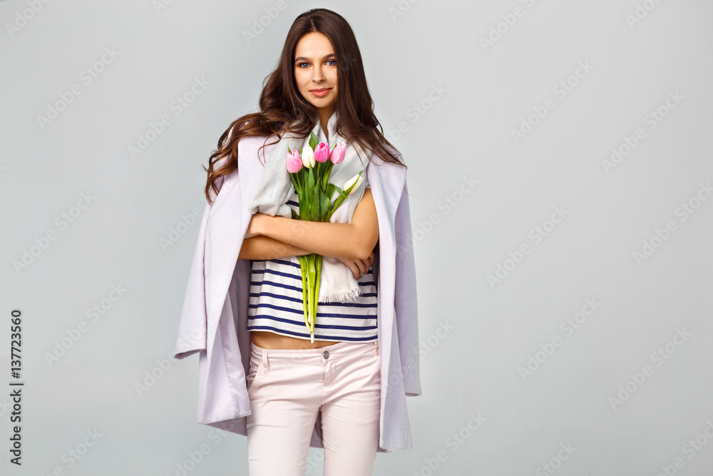 Fashion photo of a beautiful young woman with tulips in her hand .she dressed in a beautiful coat, scarf, pants and T-shirt with stripes.Spring concept. March 8. beautiful girl in stylish clothes.
Fashion photo of a beautiful young woman with tulips in her hand .she dressed in a beautiful coat, scarf, pants and T-shirt with stripes.Spring concept. March 8. beautiful girl in stylish clothes.
