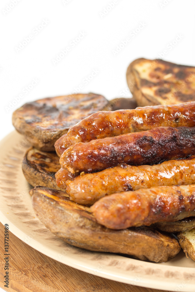 Baked potatoes with grilled bbq sausages on the plate