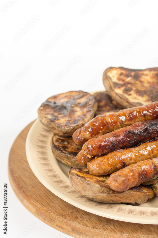 Baked potatoes with grilled bbq sausages on the plate