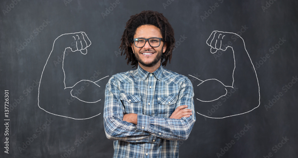 Young man against the background of depicted muscles on chalkboard