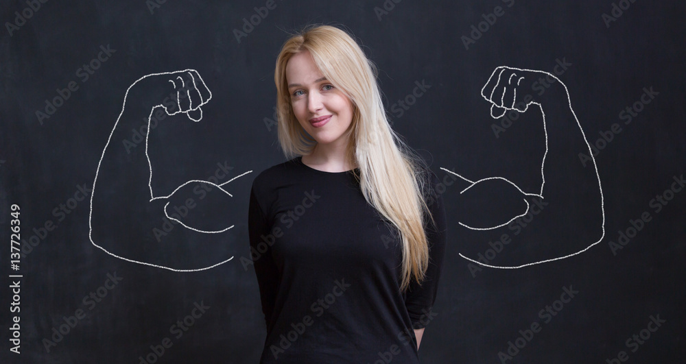 Young woman against the background of depicted muscles on chalkboard