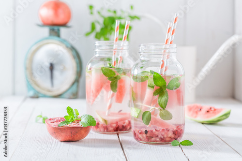 Fruity water in jar with watermelon, pomegranate and mint leaves