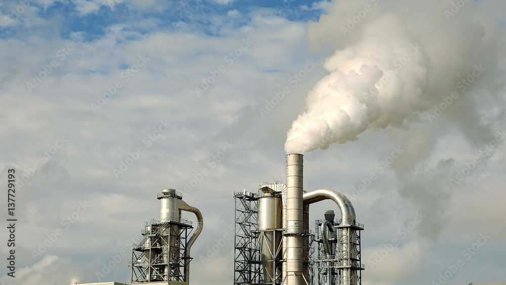 Obraz premium Factory smoke stack and pipes puff into air. Atmospheric air pollution industrial scene. Non-ecological and non-sustainable manufacturing.