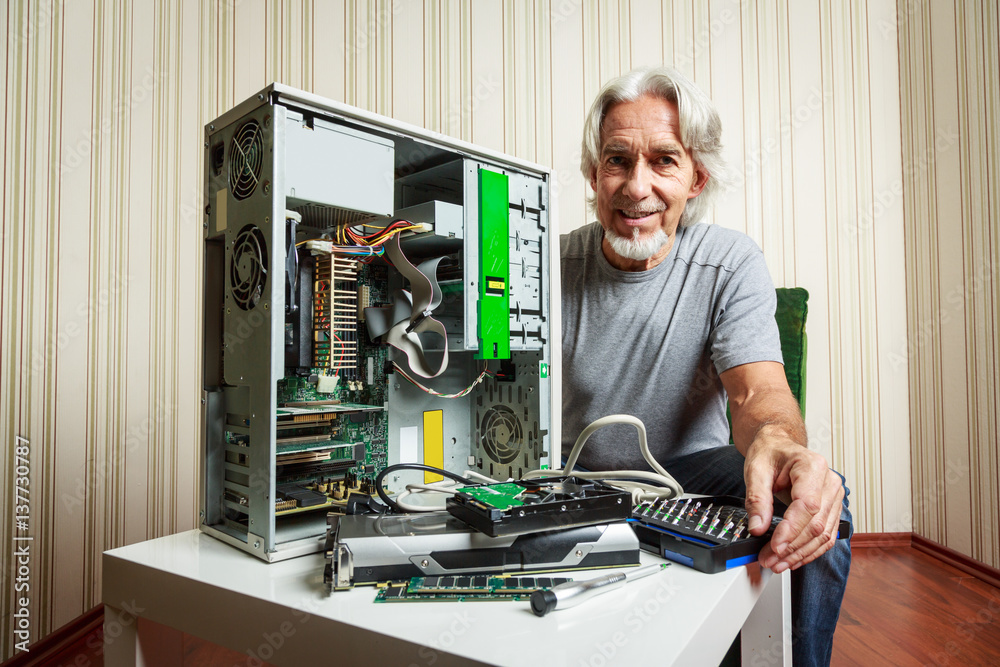 Senior Man Assembling A Desktop Computer