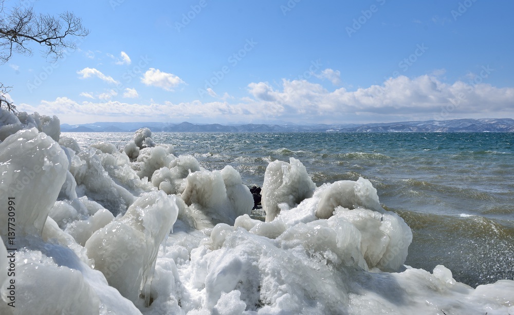 寒風と飛沫氷の湖畔の風景