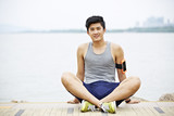 young asian man taking a break during outdoor exercise