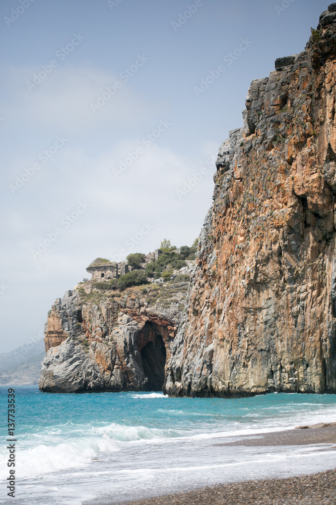 Mediterranean beach with turqouise sea and rocks on shore