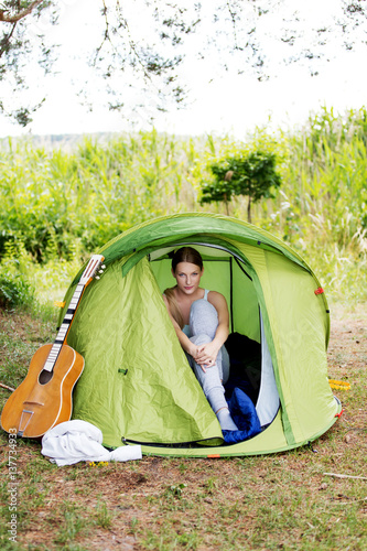 Young woman resting in a tent on the nature