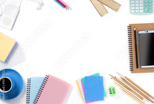 Top View of smartphone with coffee,notebook,pencil and office accessories on white background.