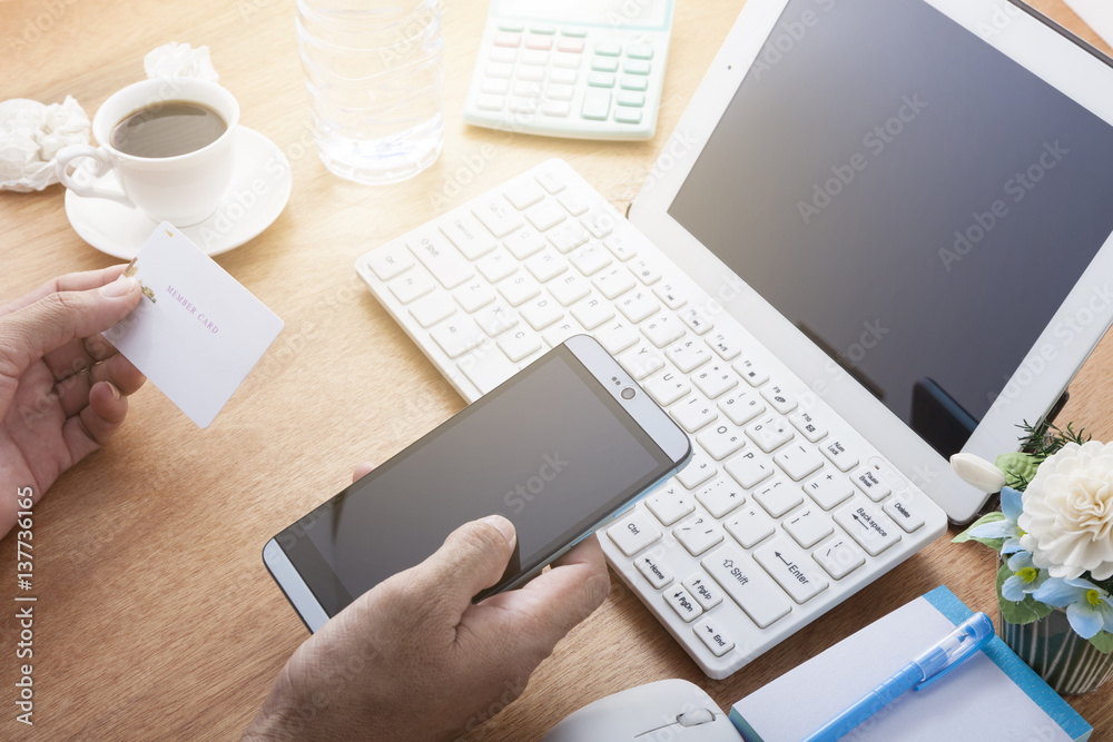 hand use smartphone with hand holding credit card on wood desk at home office, concept online payments shopping . hand use smartphone with hand holding credit card on wood desk at home office, concept online payments shopping .
