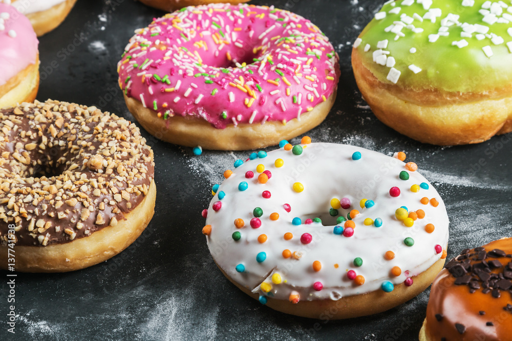 different colored donuts with different fillings on a black background