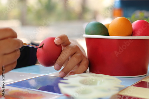 Close up eggs are being painted with child for preparing easter day. Selective focus and shallow depth of field.
