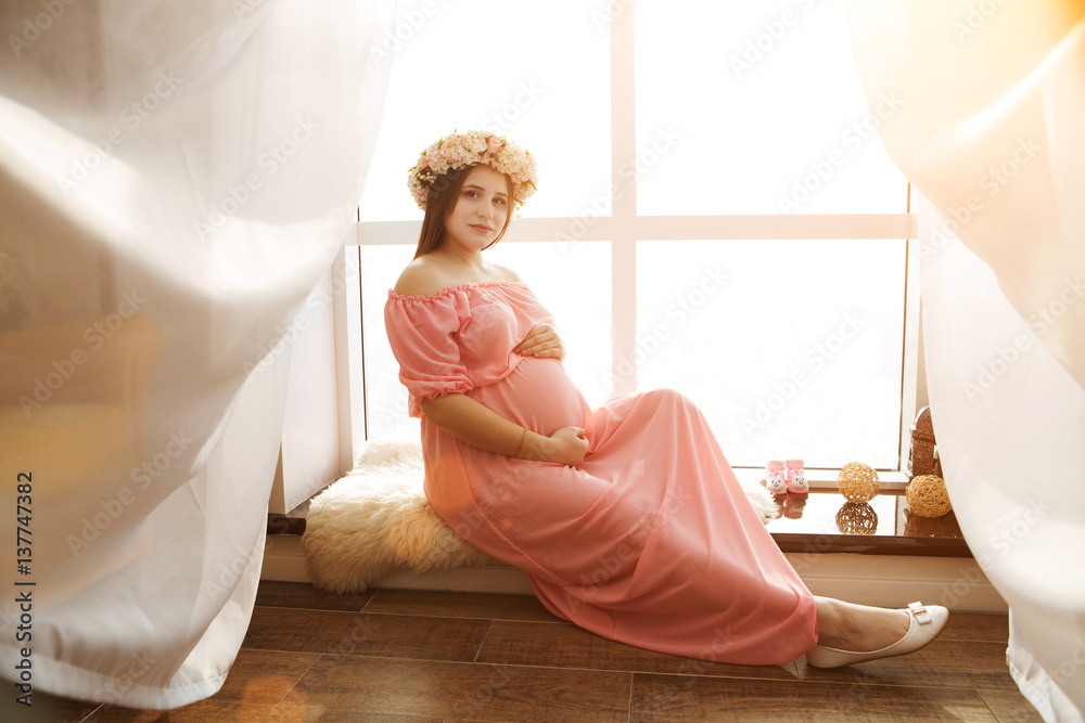 Naklejka premium Portrait Happy pregnant young woman near window