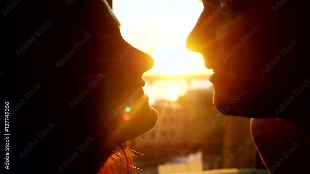 Romantic young couple silhouette is kissing looking each other on a ...