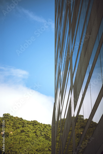 Cloudy sky mirrored in the windows of the office building. Vertical outdoors shot. photo