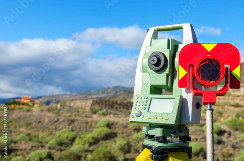 Modern surveyor equipment, theodolite with prism used in surveying and building construction for precise measurement. Total station outdoor at construction site. Copy space.