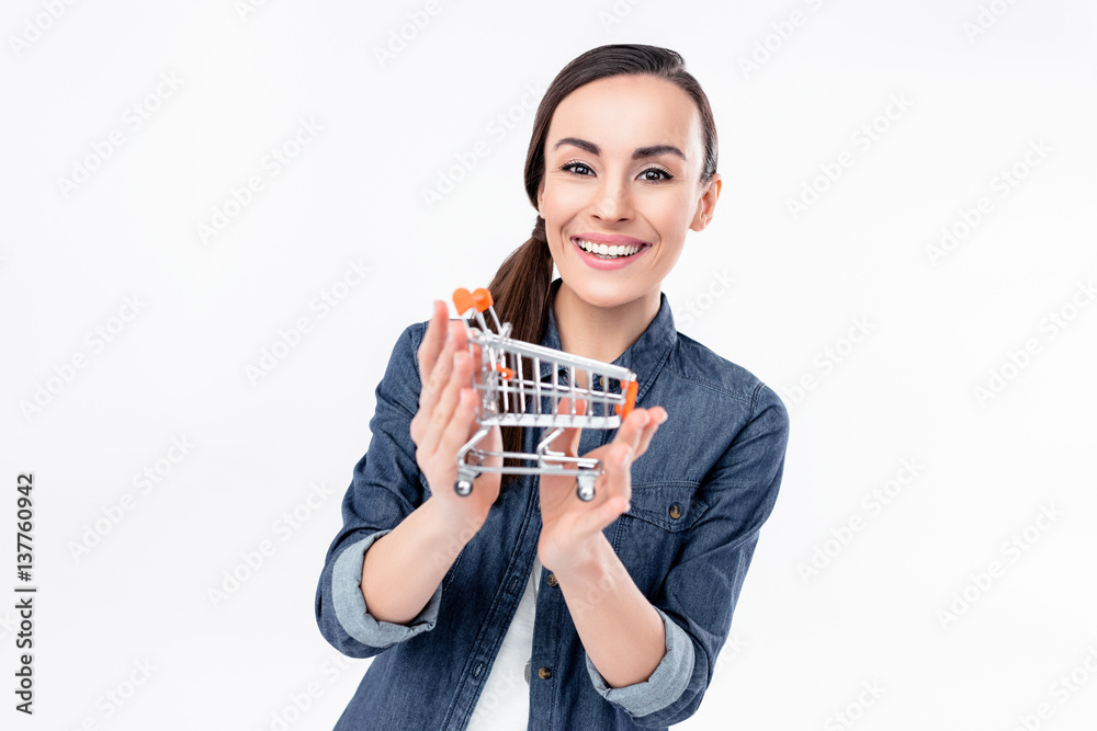 Attractive young woman holding shopping cart model and smiling at camera Attractive young woman holding shopping cart model and smiling at camera