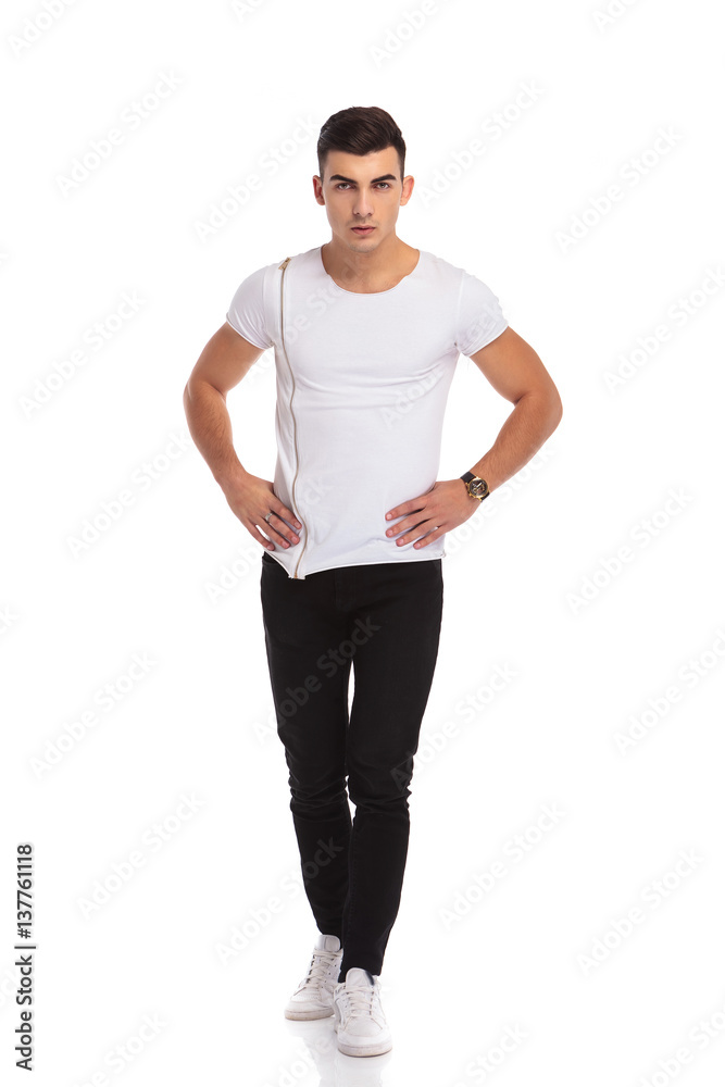 young casual man standing with hands on waist young casual man standing with hands on waist