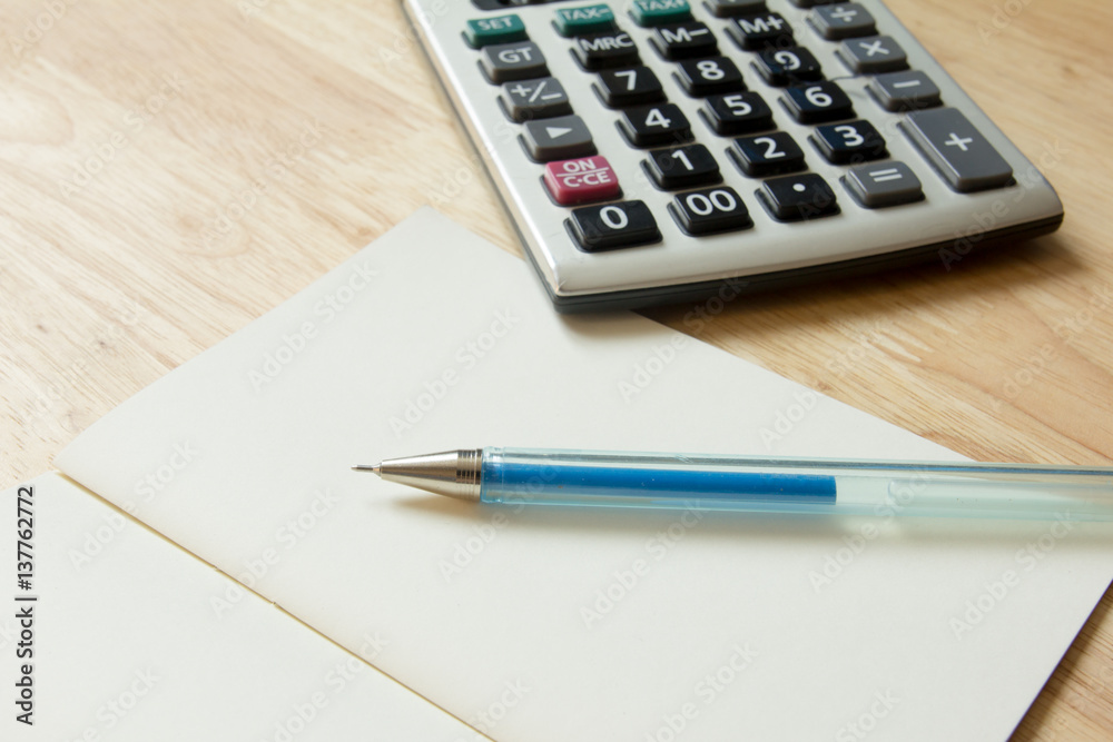 Calculator, pen, blank note book on wood table Calculator, pen, blank note book on wood table