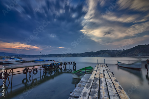 exciting long exposure seascape on harbor with wooden pier and boat © EdVal