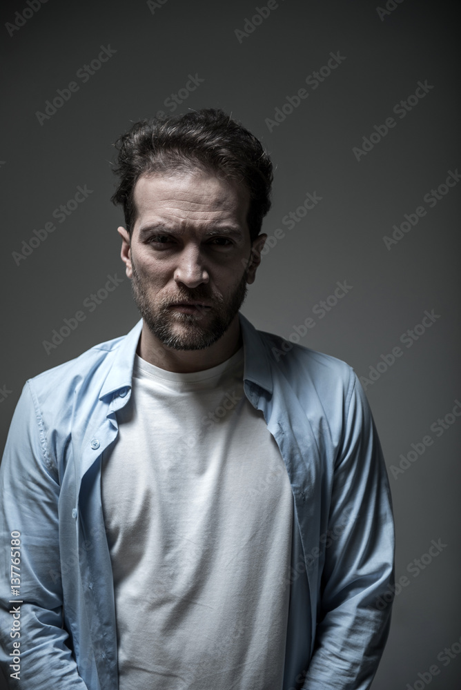 Portrait of angry man standing over grey background