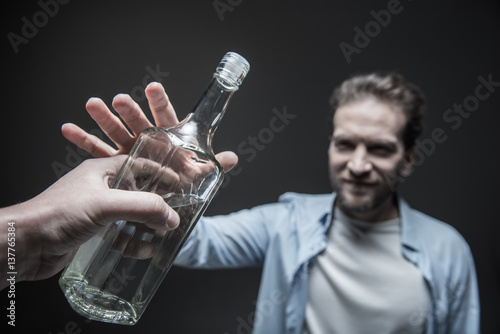 Delighted man taking big glass bottle