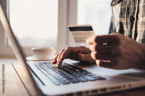Man holding credit card and using laptop. Online shopping concept © kite_rin