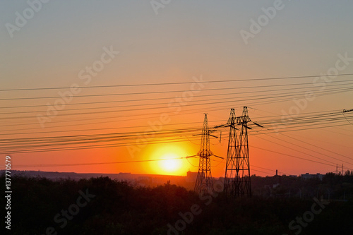 electric pylons and wires on sunset background