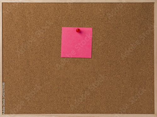 Pink Blank sticky notes red pinned into brown corkboard