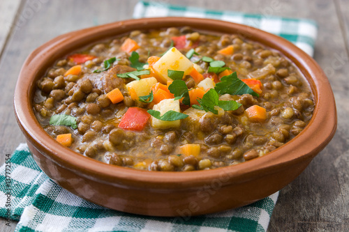 Lentil soup in a bowl on wooden background 