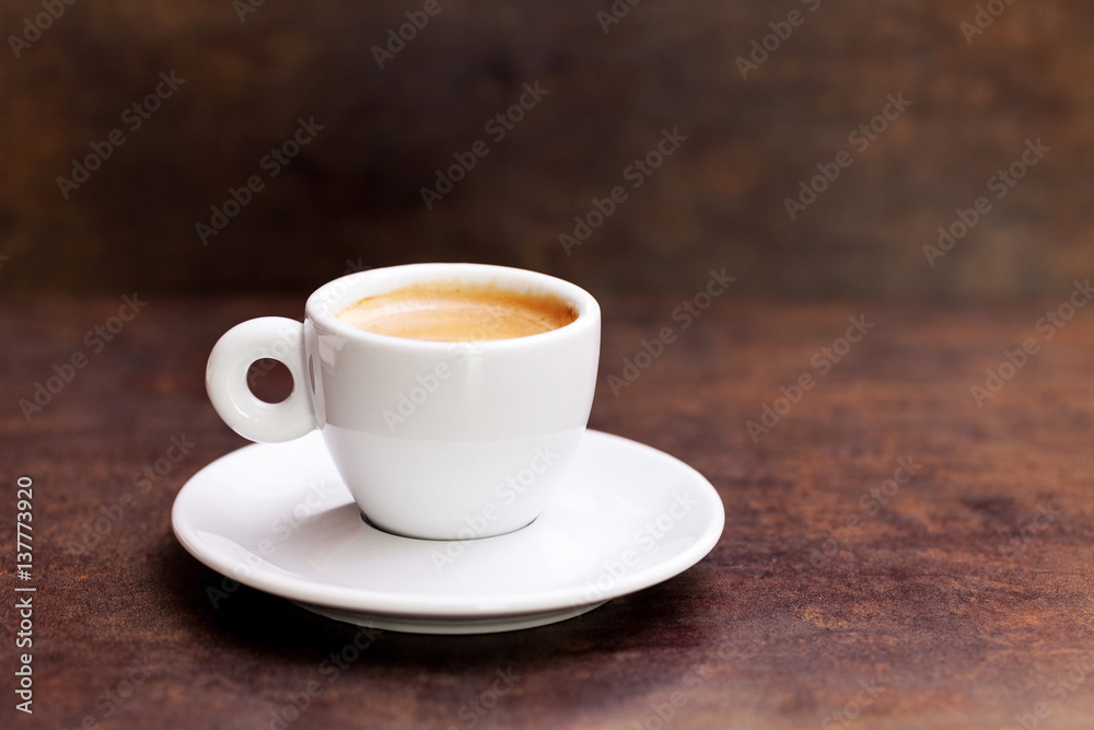 White cup of espresso coffee on background.
White cup of espresso coffee on background.