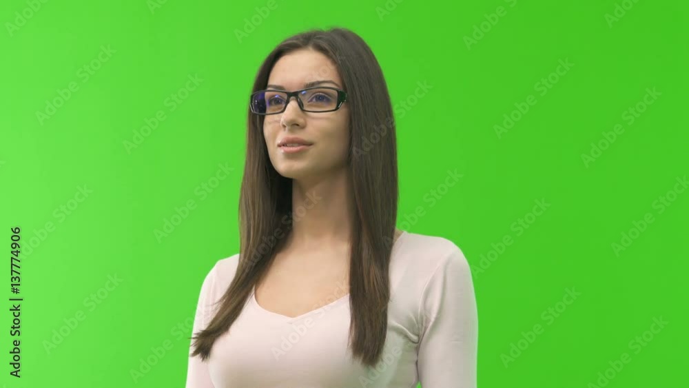 The woman in glasses stand on the green screen background The woman in glasses stand on the green screen background
