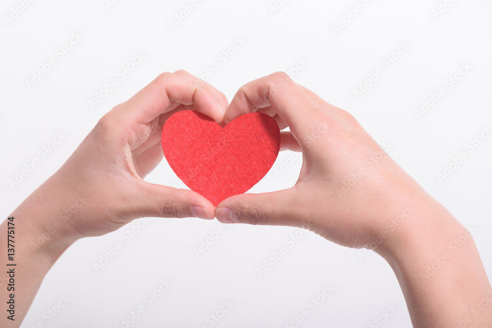 Obraz premium Valentines day and love concept.Two hands holding a red heart shape decoration on white background.