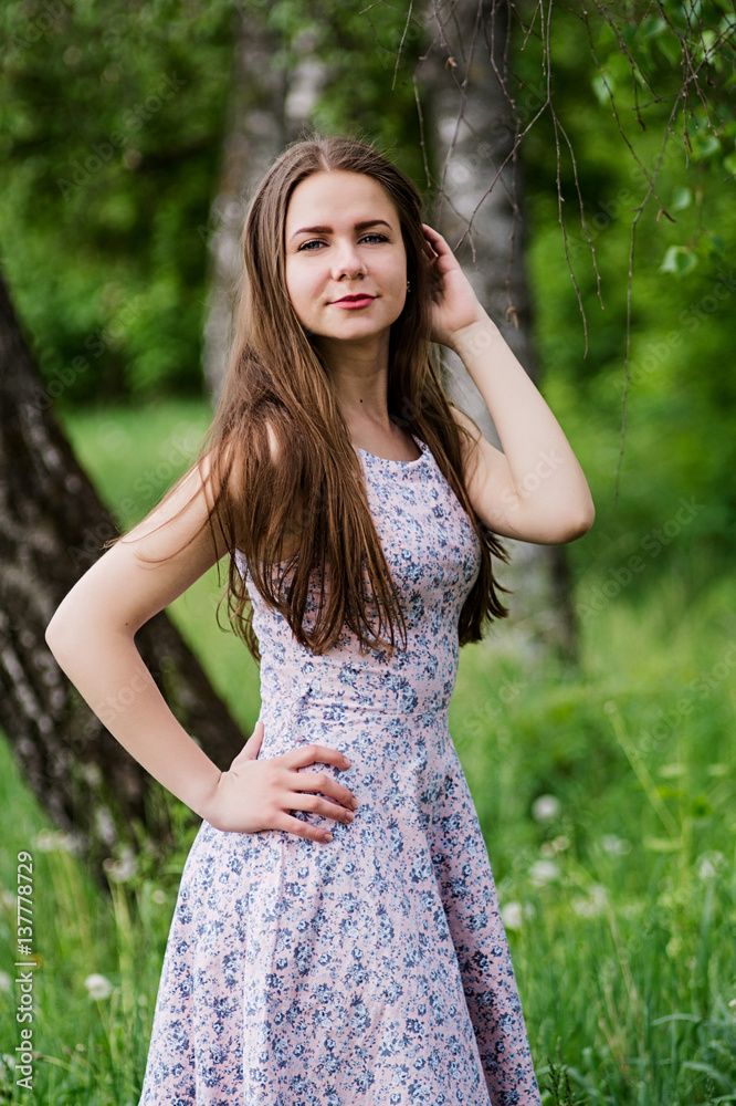 Attractive girl posing at garden,holding hand on waist.