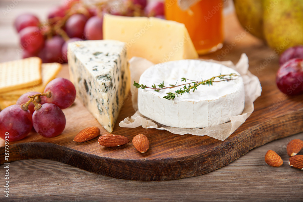 Cheese, honey and fruit on a table. Selective focus. Copy space. Cheese, honey and fruit on a table. Selective focus. Copy space.