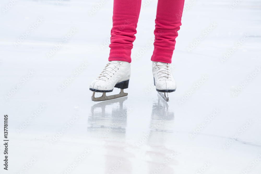 Woman skating with white skates on the ice area at the seashore in winter day. Weekends activities outdoor in cold weather. Woman skating with white skates on the ice area at the seashore in winter day. Weekends activities outdoor in cold weather.