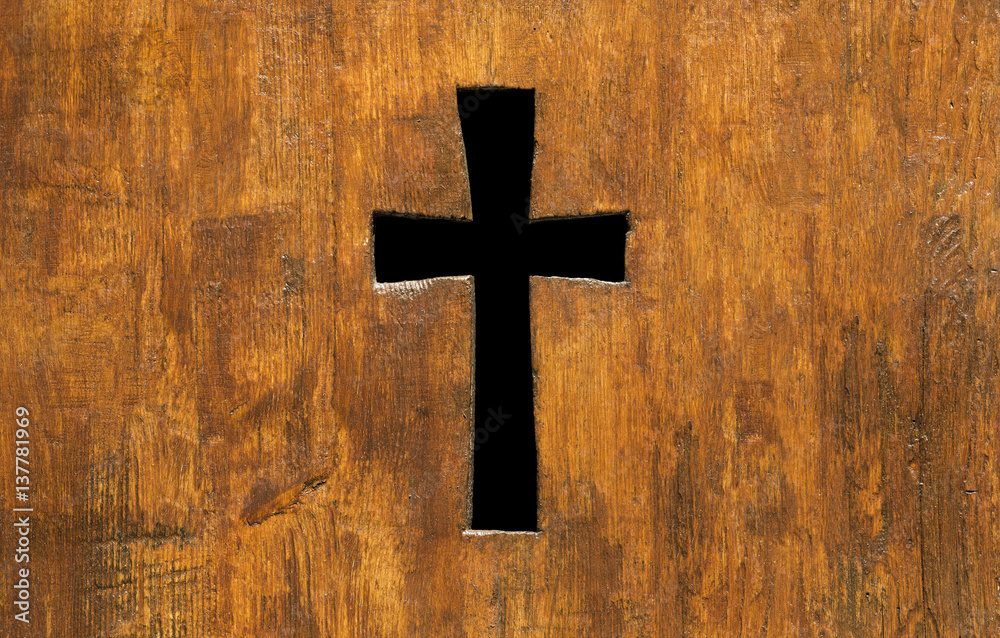 Cross shape hole in a church wooden fence