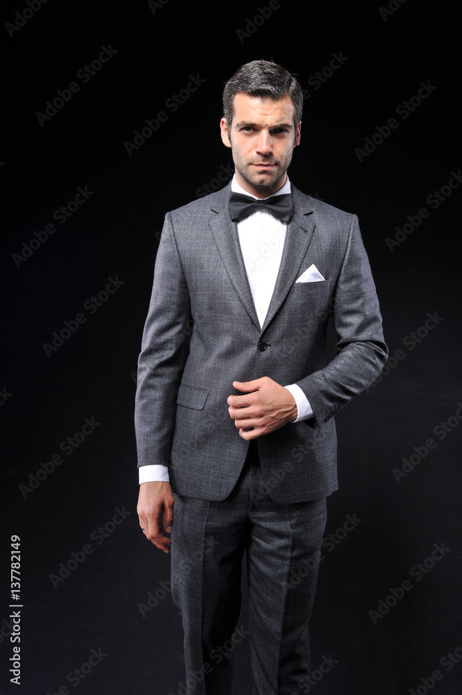 young business man posing with gray suit and bow tie young business man posing with gray suit and bow tie