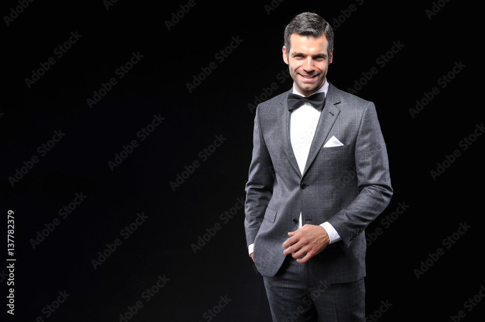 young business man posing with gray suit and bow tie young business man posing with gray suit and bow tie