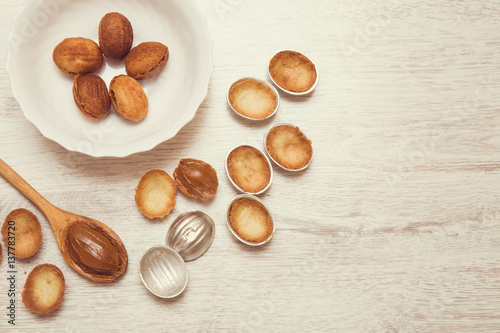 In the kitchen from shortcrust pastry baked tasty nuts shapes with sweet, brown cream - condensed milk. Homemade pastries.