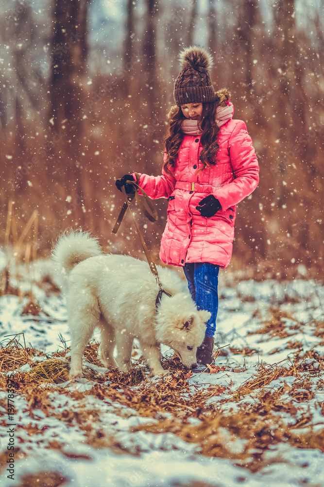 Happy girl with Samoyed dog in winter forest Happy girl with Samoyed dog in winter forest