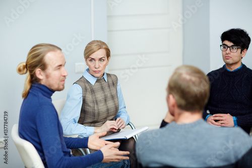 Experienced psychologist and group of patients discussing their problems