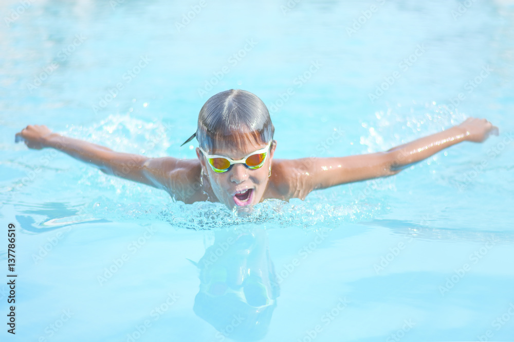 Close up action shot of boy swimming butterfly