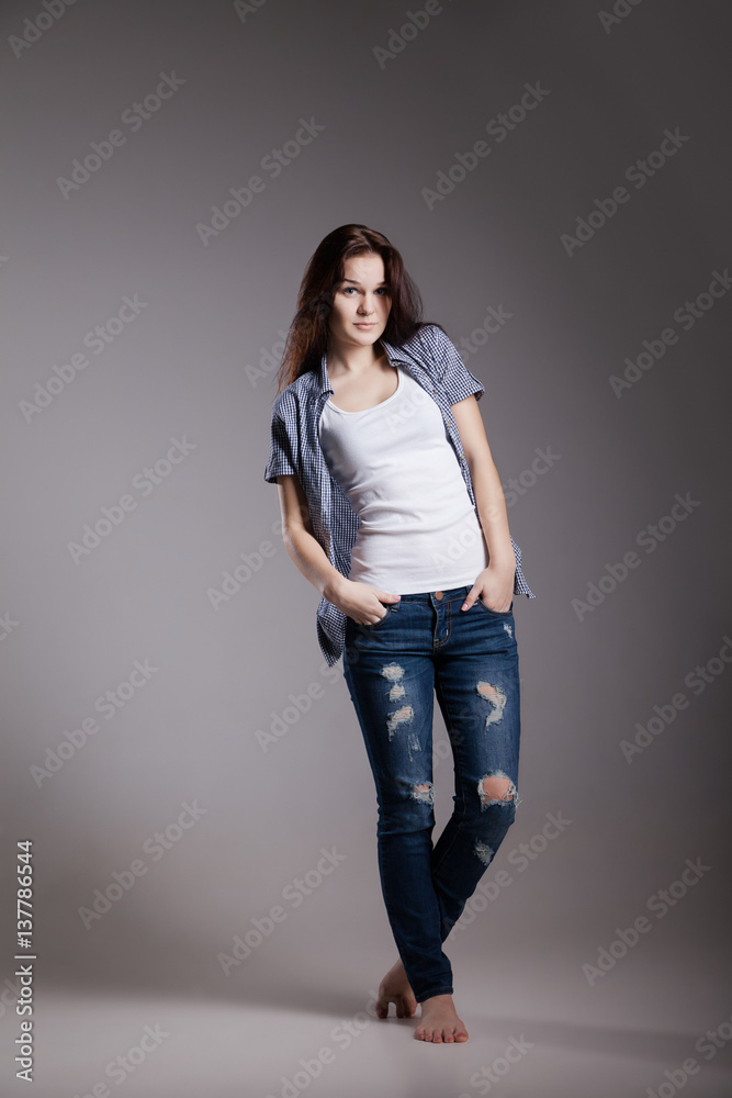 Portrait of an attractive young woman in casual jeans clothes possing at studio Portrait of an attractive young woman in casual jeans clothes possing at studio