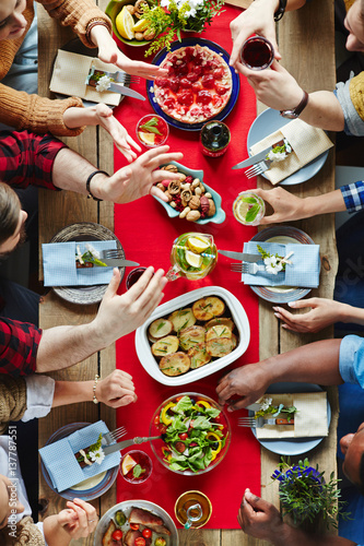 Group of friends talking by served festive table
