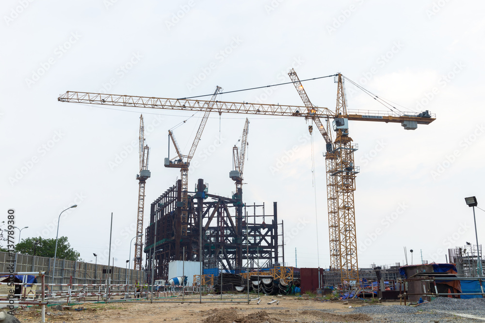 Construction site with three working tower cranes background