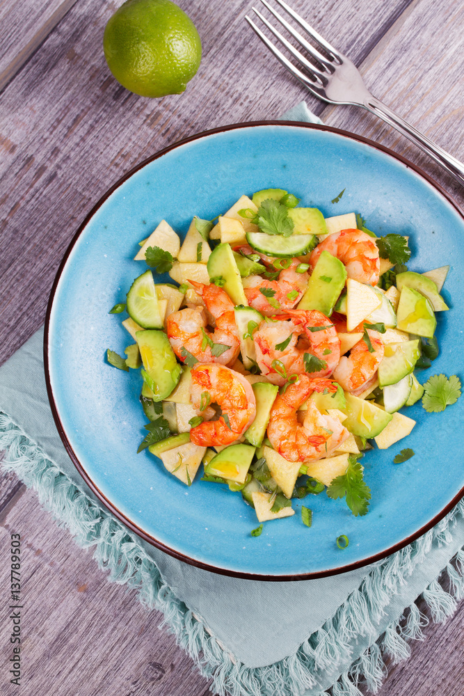 Shrimp, Avocado, Apple and Onion Salad. Grilled prawns on blue plate. View from above, top studio shot Shrimp, Avocado, Apple and Onion Salad. Grilled prawns on blue plate. View from above, top studio shot