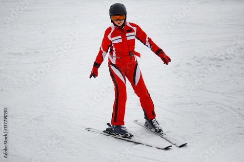 young girl in a red suit skis
