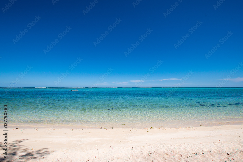 Deserted sandy beach with turquoise sea and blue sky - Mauritius