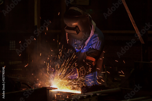 Worker is welding in factory 